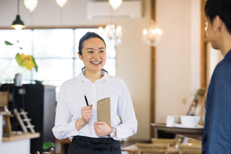 笑顔を見せるカフェ店員の女性