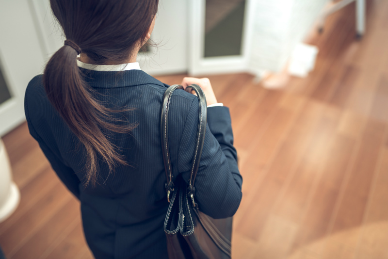 鞄を持つスーツ姿の女性