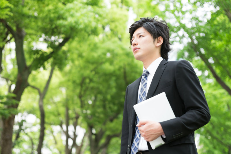 真剣な表情で何かを見つめるスーツの男性