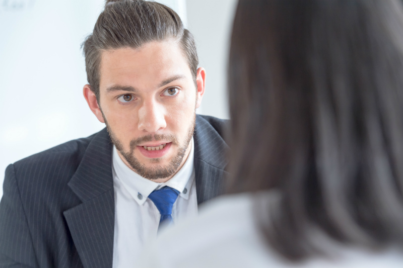 外国人男性と話している日本人女性の後ろ姿