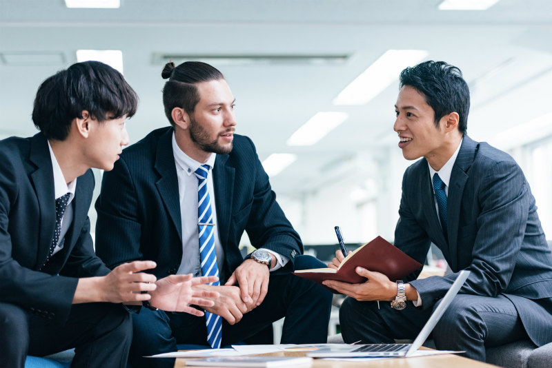 オフィスで話し合っている日本人男性と外国人男性