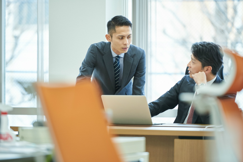 上司と話している若い男性