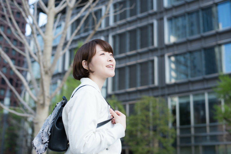 オフィス街を歩く若い女性