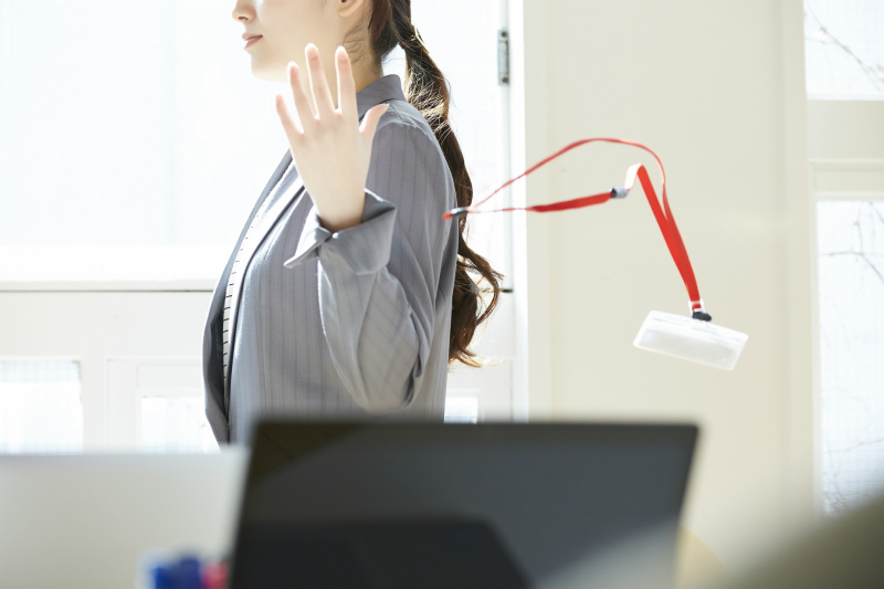 社員証を放り投げる女性