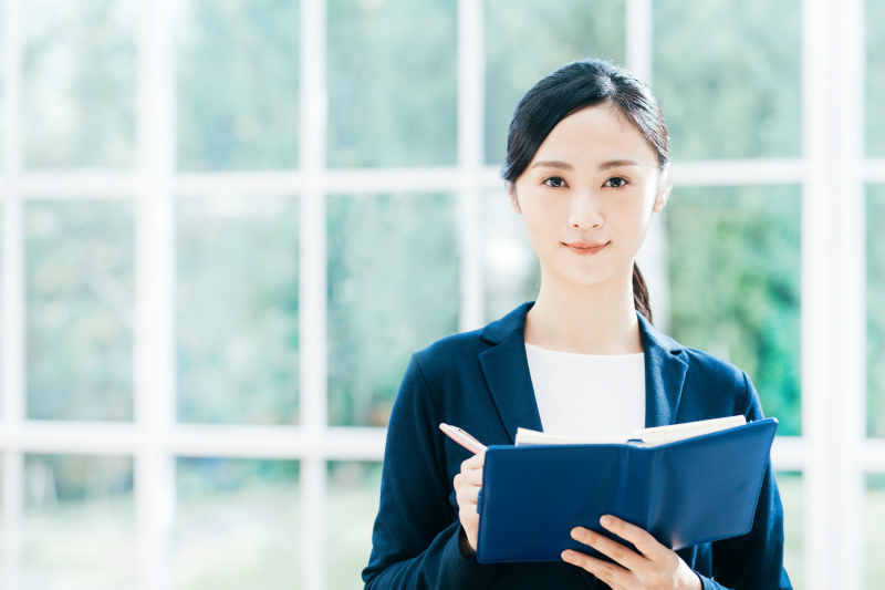 ノートにメモをとる女性