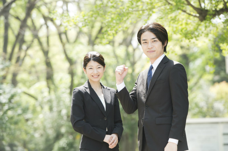 緑の多い屋外で立っている2人の若い男女