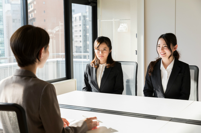 面接官の目を見つめる二人の女性