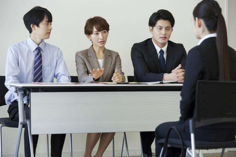 三人の面接官と応募者の若い女性