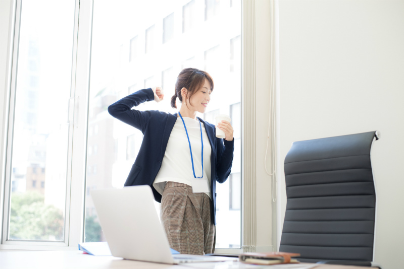 オフィスでコーヒーを飲みながらくつろぐ女性