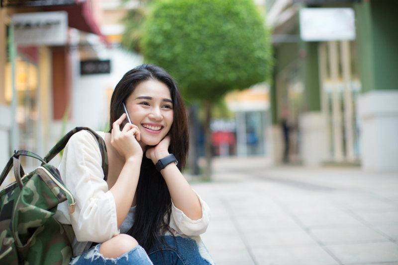 電話する笑顔の若い女性