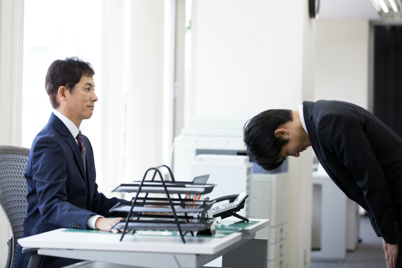 上司に頭を下げる部下