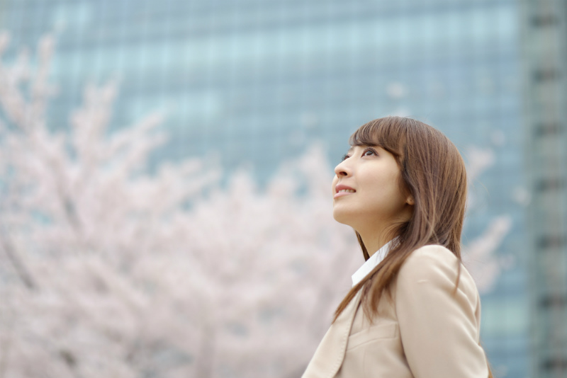 空を見上げるスーツを着た女性