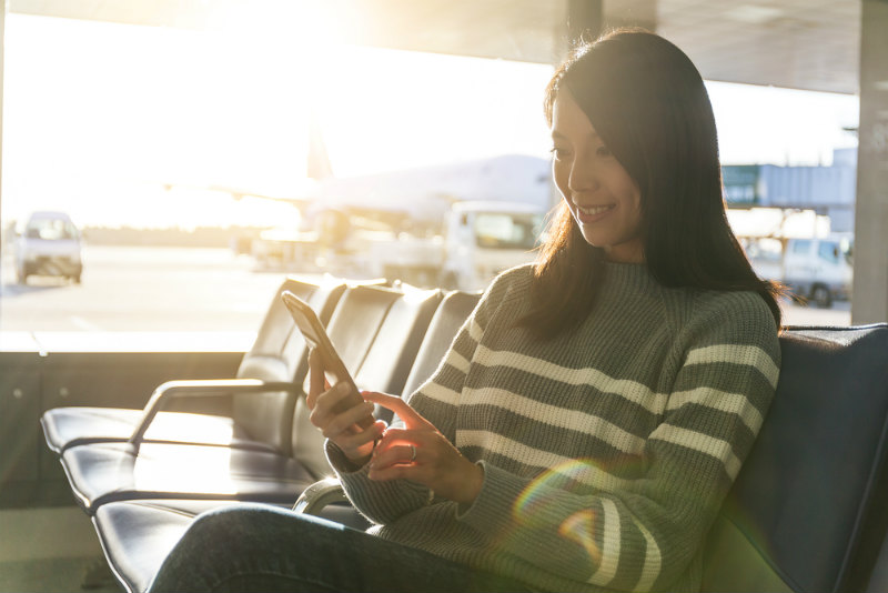 空港でスマホを見る女性